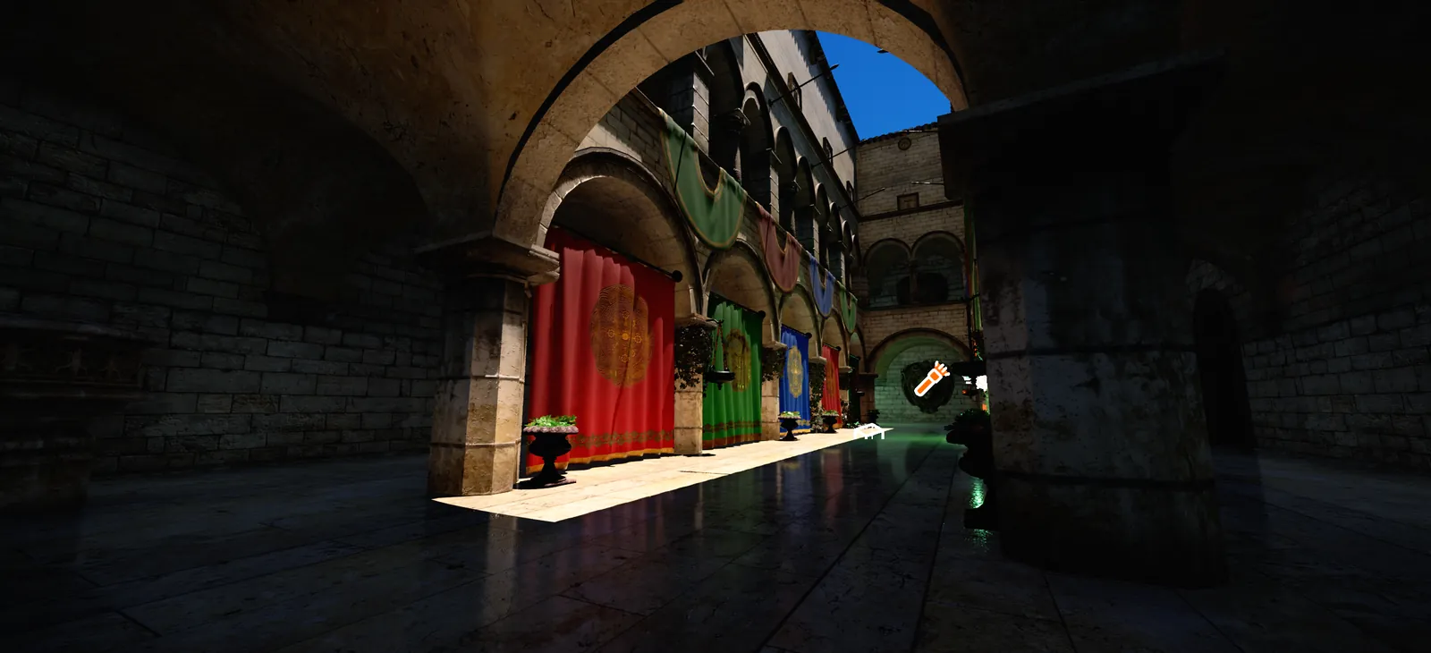 Sunlight falls through stone arches onto a polished floor, with red, green and blue drapes hanging along the colonnade